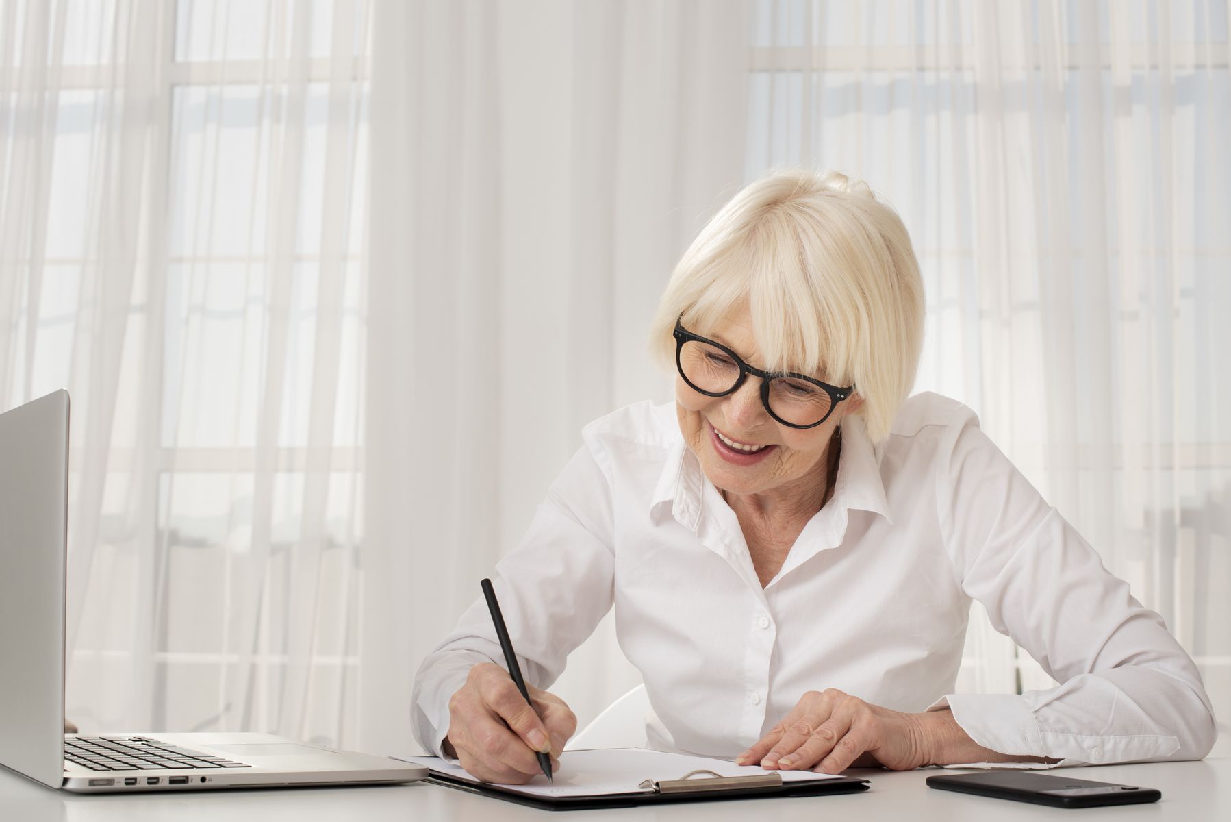 Senior écrit sur un presse-papiers