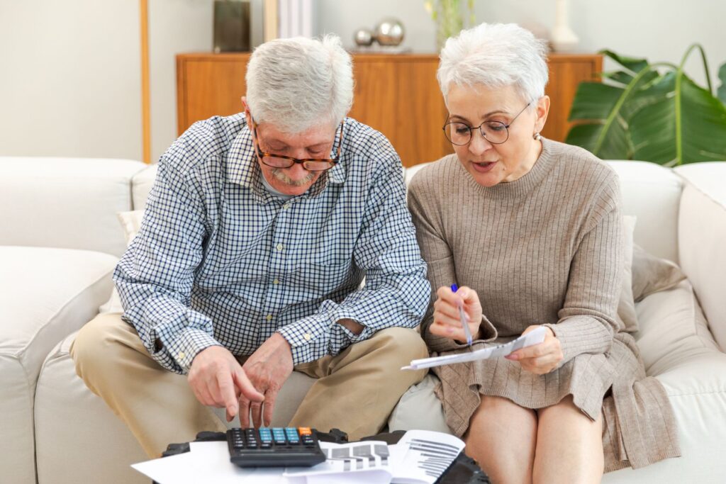 Couple de seniors qui détermine le coût réel d'une place en maison de retraite