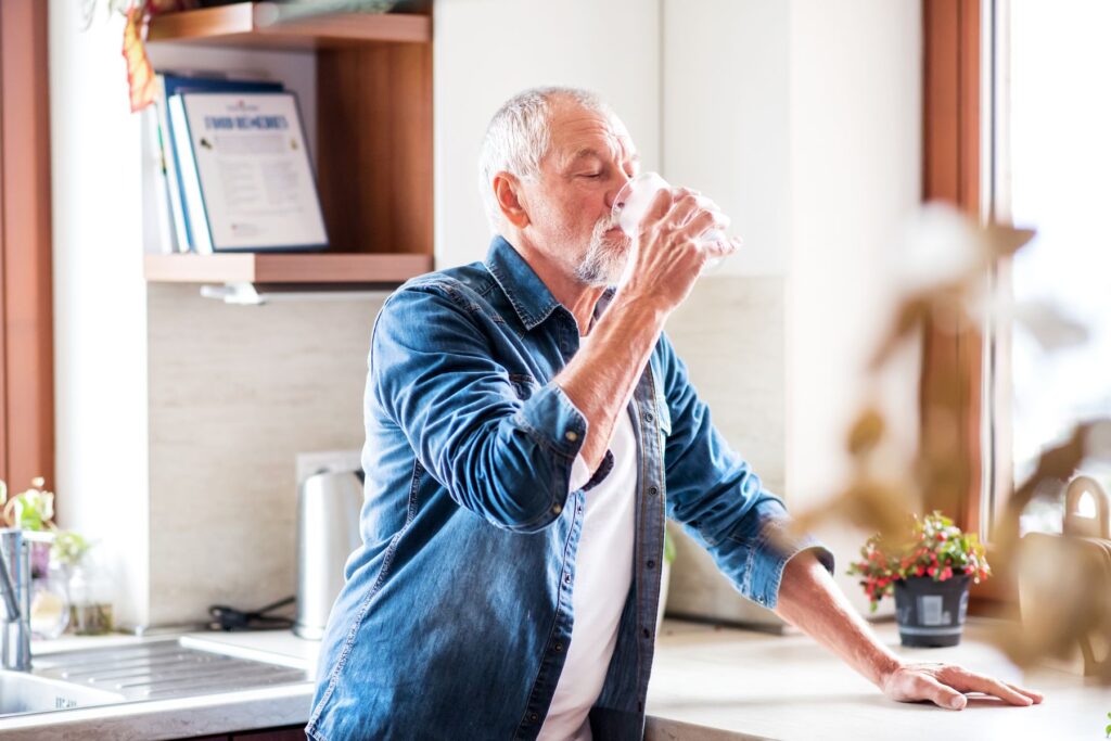 Senior qui s'hydrate contre la chaleur