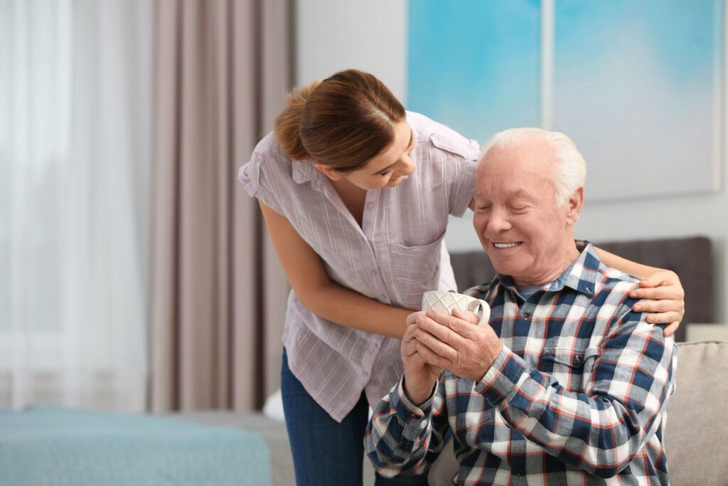 senior avec une assistante au repas en EHPAD