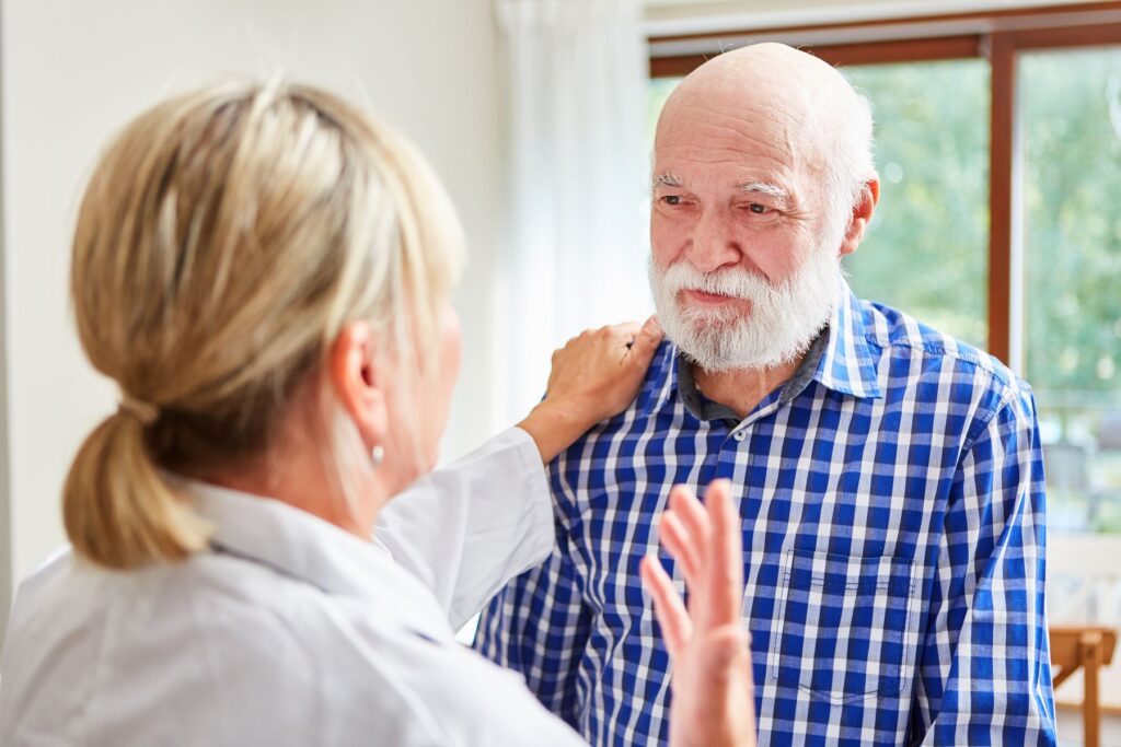 Senior qui s'agite accompagné par une aide soignante en EHPAD